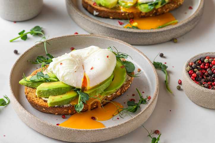 Sandwiches with avocado, poached egg, sprouts.