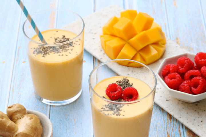 Mango and ginger smoothies with fruit and ginger on the side