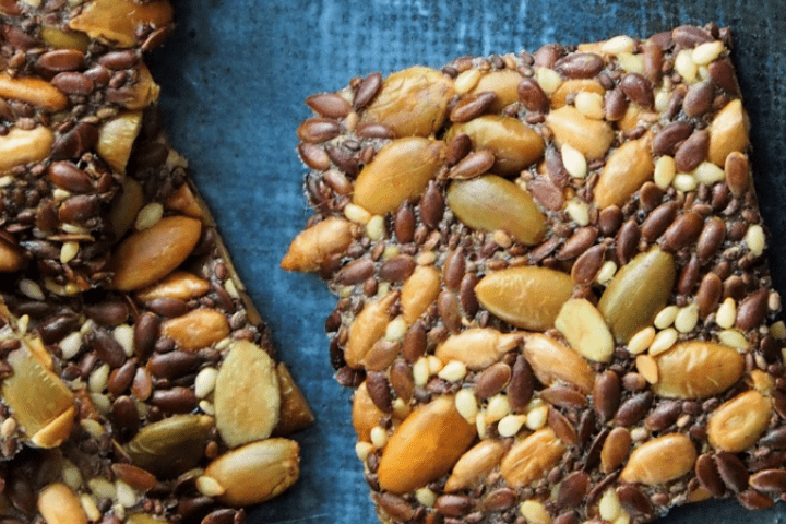 A close-up of seedy crackers on a blue background.