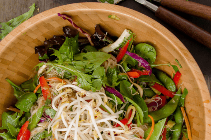 Zesty Thai noodle salad in a wooden bowl.
