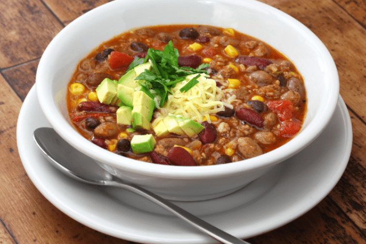 Bowl of bean chilli with avocado on top