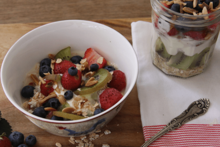 Cereal in a bowl with kiwifruit, strawberries and blueberries