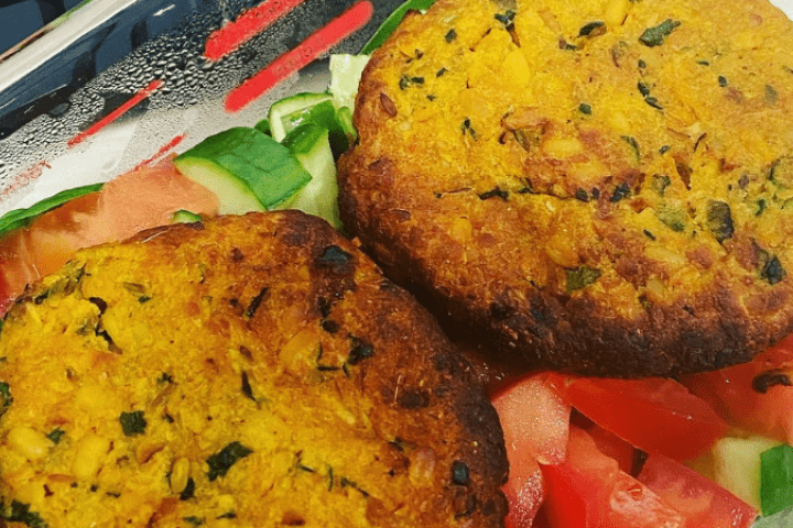 Two lentil patties on a plate with salad