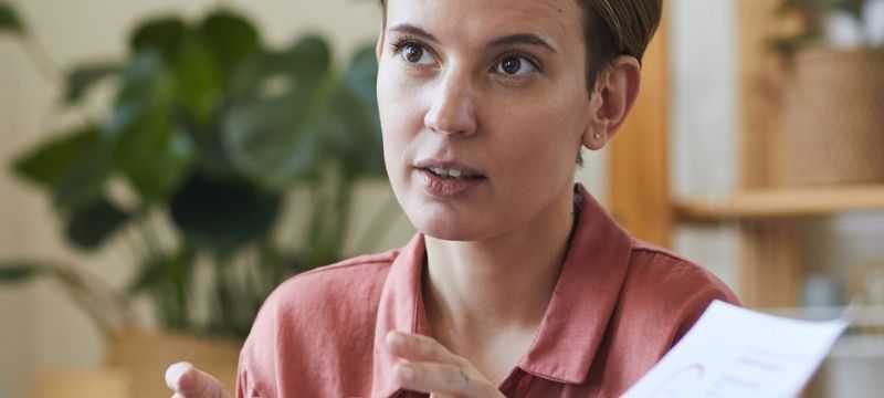 Woman consulting with man who is holding a piece of paper.