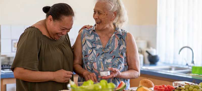 Two women cooking in kitchen.