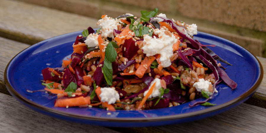 Beetroot farro honeyed walnut super salad served on a blue plate.