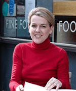 Woman with blonde hair and red top holding some papers