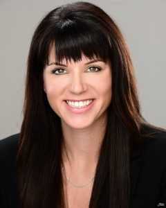 Woman with long brown hair smiling at camera