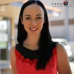 Woman with black hair and red top smiling at camera