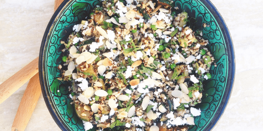 Minty green quinoa brown rice salad served in a blue bowl.