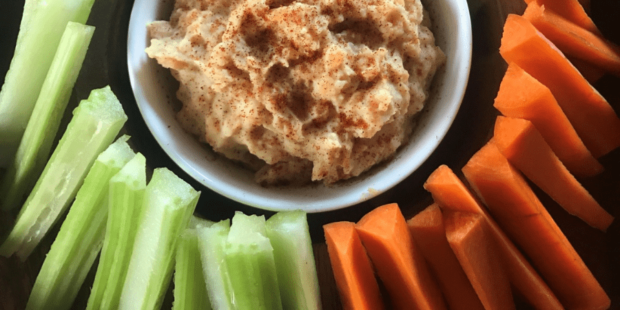 Red lentil hommus served with celery and carrot.