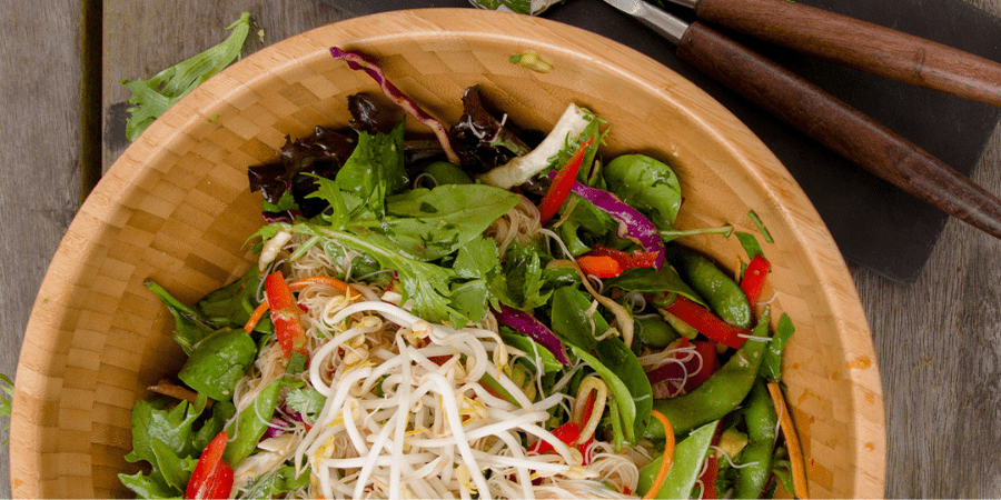 Zesty Thai noodle salad in a wooden bowl.