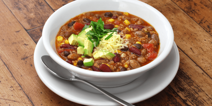 Bowl of bean chilli with avocado on top