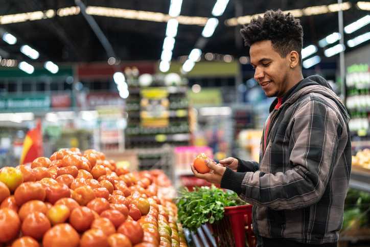 Man choosing tomatoes at supermarket