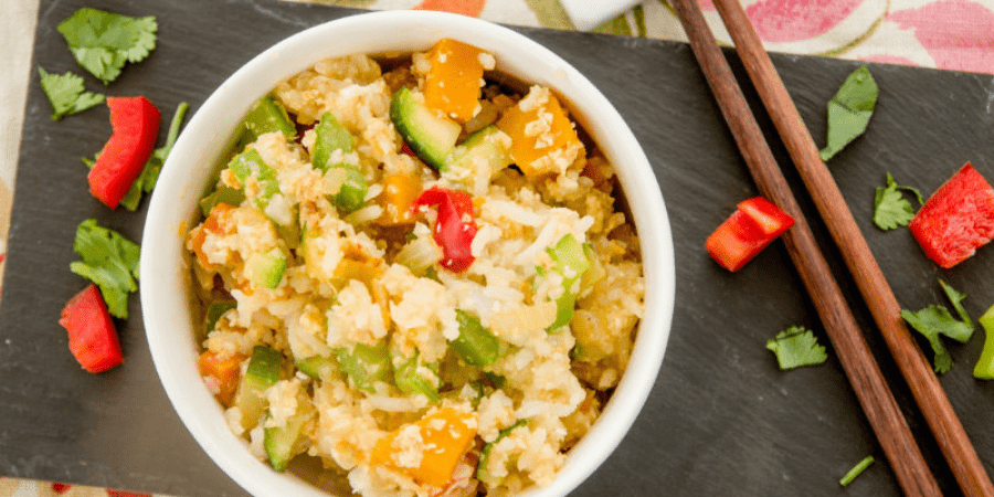 Rice and vegetables in a bowl on a black platter