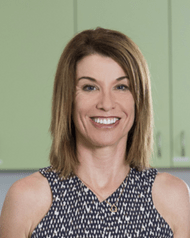 Woman with shoulder length brown hair smiling at the camera