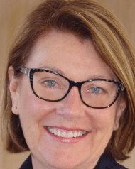 Woman with glasses and light brown hair smiling at the camera