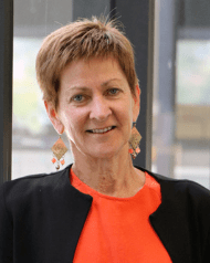 Woman with orange shirt and black blazer looking at the camera