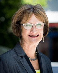 Woman with glasses smiling at the camera