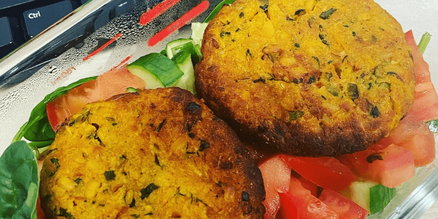 Two lentil patties on a plate with salad