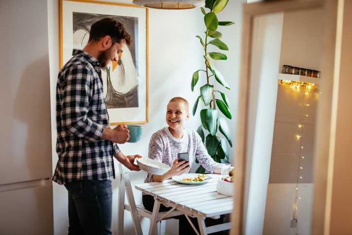 Man serving food to a woman who has been undergoing cancer treatment