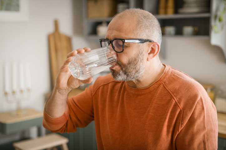 Older man drinking a glass of water