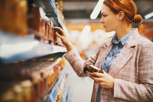 Woman reading food labels at the grocery store