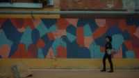 Michelle walking in front of a building with graffiti